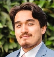 Professional headshot of Dylan Landkammer against a natural background.